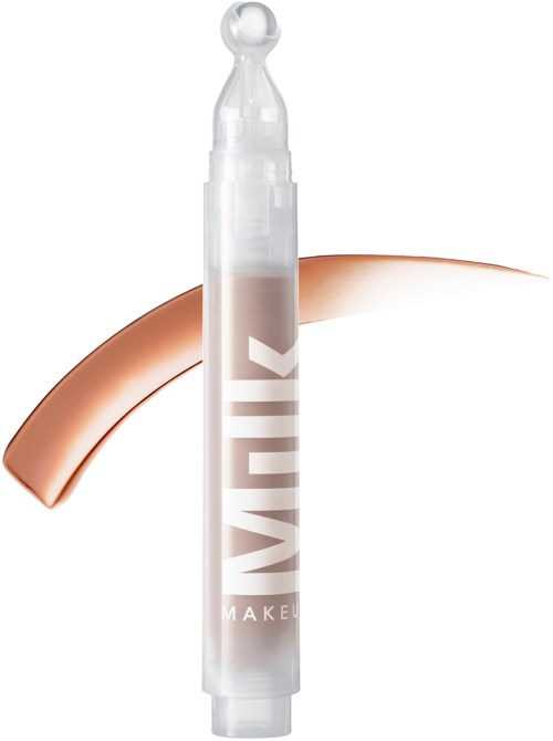 Een witte penvormige container met doorzichtige dop, met de tekst 'MILK' en een streepje romige make-up.