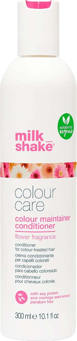 En hvit flaske med milkshake fargebevarende balsam med rosa og blomsterduft, egnet for farget hår, og merket som vegansk.