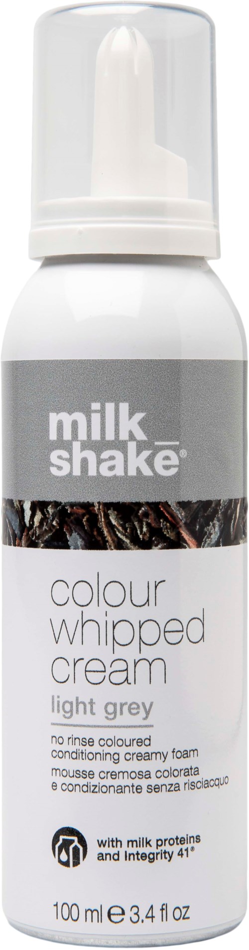 Een witte fles met pomp, gemerkt 'milk shake', bevat lichtgrijze haarstylingsop.