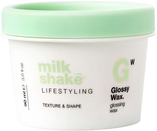 Een container met glanzende wax voor haar, gelabeld 'milk shake' en 'lifestyling' met een lichtgroene deksel.