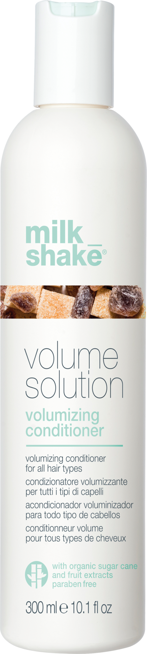Een witte fles met 'milk shake' label bevat volumiseerconditioner voor alle haartypes, met biologische suiker en fruitextract.