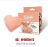 A box of medicine with a pink heart-shaped plush toy next to it. The box is orange and white with text.