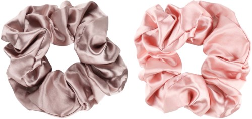 Två satinscrunchies, en beige och en rosa, är placerade bredvid varandra på en vit bakgrund.