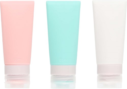 Three pastel-colored tubes stand next to each other, one pink, one blue, and one white. Each has a white cap.