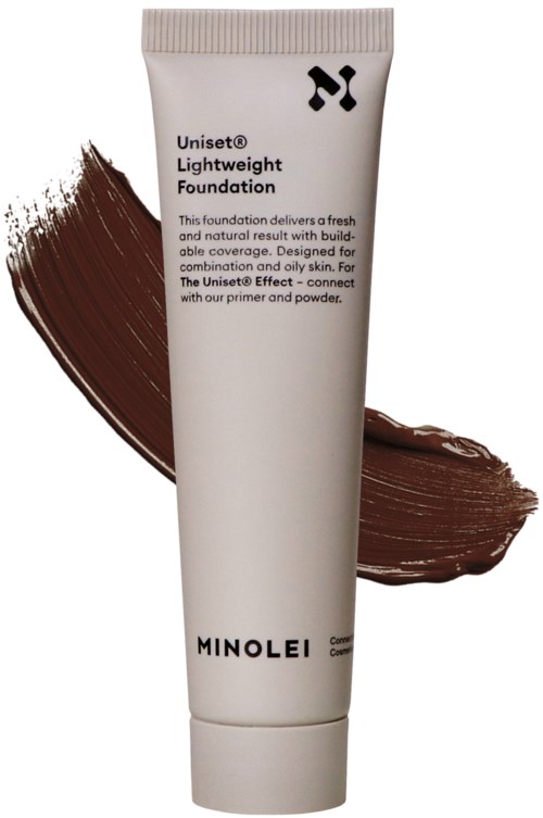 En vit tub märkt 'Uniset Lightweight Foundation' med brun makeup bakom.