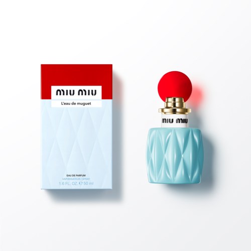 Een parfumfles met een blauw gevlochten ontwerp en rode dop, naast de doos met rood, wit en blauw.