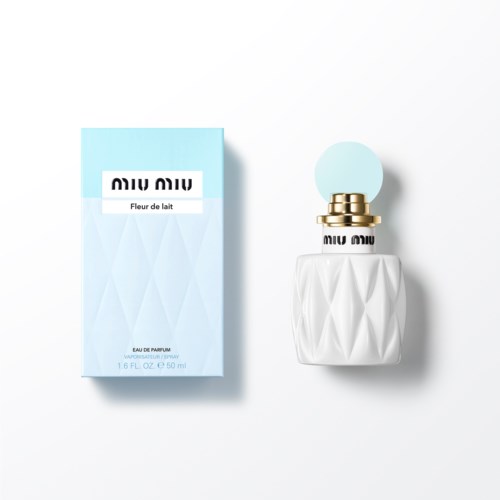 Miu Miu parfumfles met witte geometrische stijl en lichtblauw doosje.