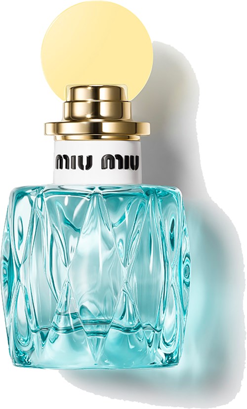 Een glazen parfumfles met blauwe vloeistof, gouden dop en een ronde gele top, werpt een schaduw.