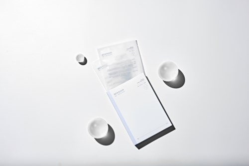 Een tablet ligt open, omgeven door drie witte eieren op een effen witte achtergrond.