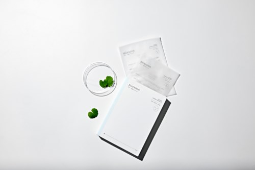 Een medicijnfles met tabletten en twee kleine groene planten op een witte achtergrond.