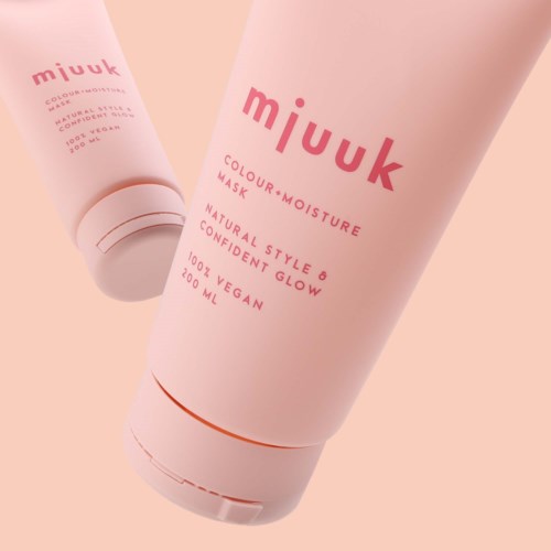 Twee roze tubes huidverzorgingsproducten met merkgeving en tekst op een lichte achtergrond.