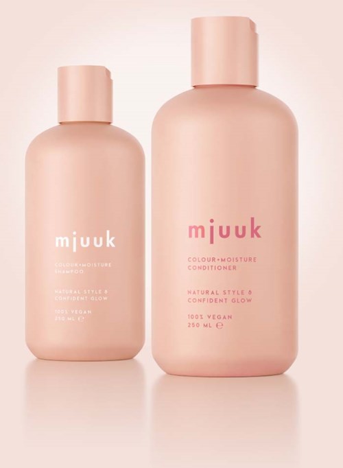 Twee roze flesjes met 'miuuk' erop, klein en groot, voor een lichtroze achtergrond.