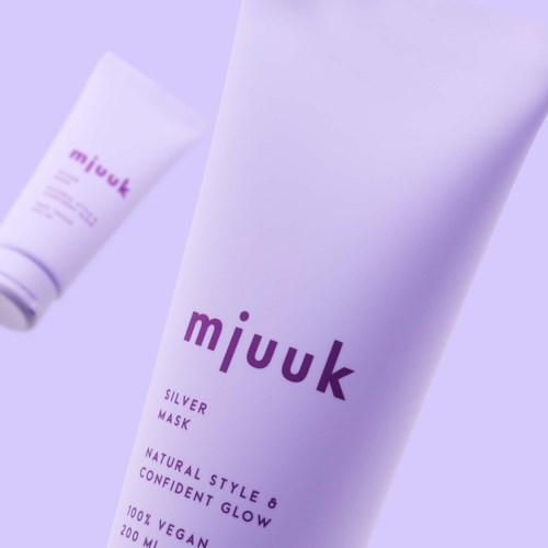 Grote witte tube met 'mjuuk' in paars, voor zilver masker voor huidverzorging.