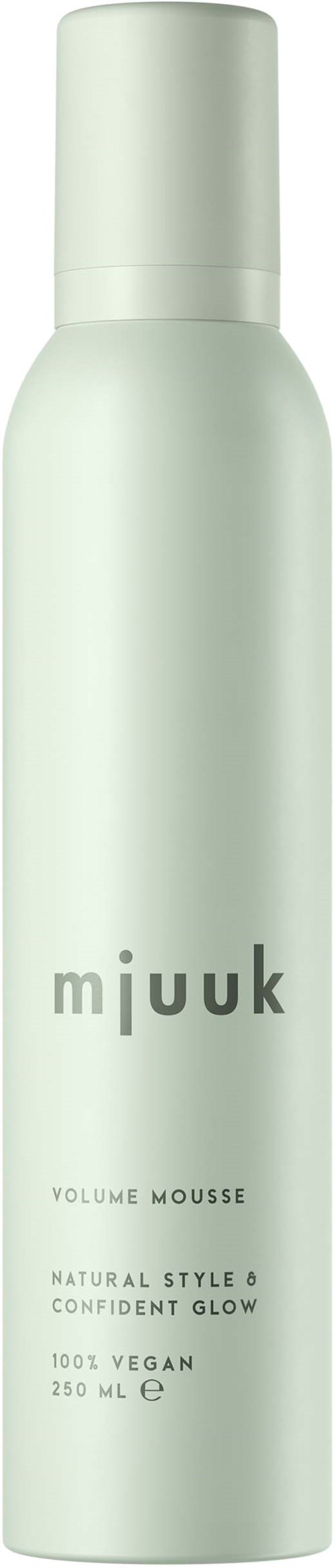 Een lange, witte fles met "mjuuk" erop, bevat volume mousse, vegan en glow.