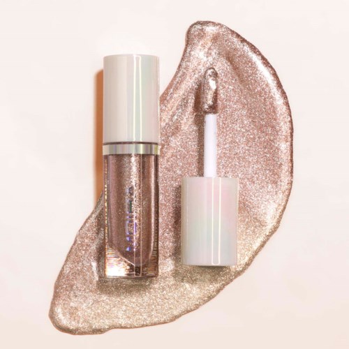A lip gloss with a white cap and a shiny, glittery background. The gloss appears to have a metallic shimmer.