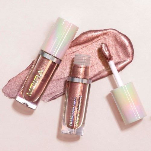 Two shiny lip gloss bottles and a gloss on a pink streak. The bottles have iridescent caps and a soft metallic look.