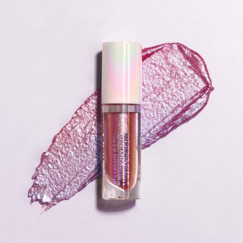 A shiny lip gloss with a holographic cap, placed on a pink textured leaf background.