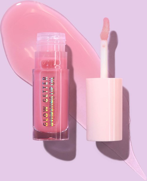 A pink lip gloss tube with a white wand lies on a lavender background, with a smear of gloss nearby.