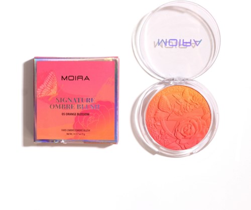 A compact blush with orange and pink shades, and its pink packaging box watching a scene opposite to the blush.
