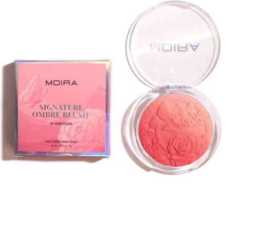 A pink compact blush with engraved flowers, next to a pink box with floral designs and product details.