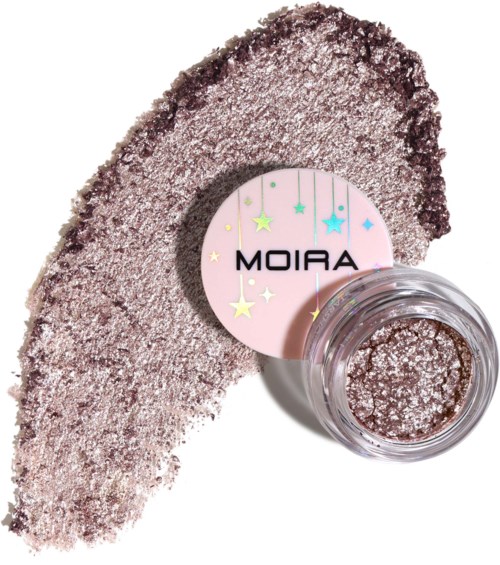 Pinkish shimmering eye shadow with a small round container and a card labeled "MOIRA" featuring stars.