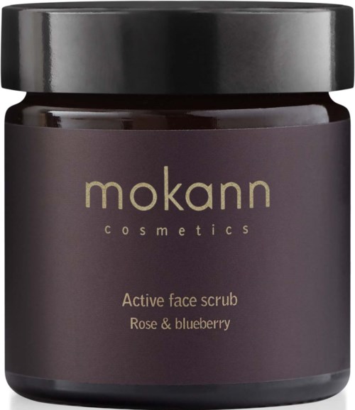Ein dunkelvioßer Behälter mit schwarzem Deckel, beschriftet 'mokann cosmetics, Active face scrub, Rose & blueberry.'
