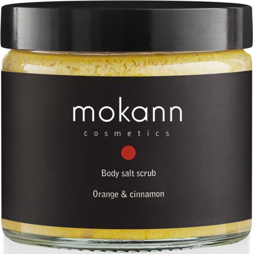 Ein Glas von Mokann Cosmetics mit Körper Salzpeeling Duft nach Orange und Zimt. Schwarzer Deckel und Etikett. Gelbes Salz sichtbar im Inneren.