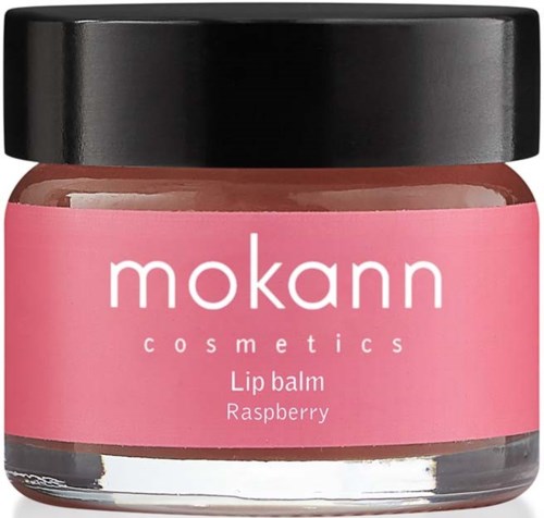Ein kleiner rosa Behälter mit der Aufschrift 'mokann cosmetics Lip balm Raspberry' und schwarzem Deckel.