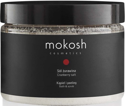 Een potje met Mokosh cosmetics met cranberryzout, bad en scrub ingrediënten, zwarte deksel en simpel donker labelontwerp.
