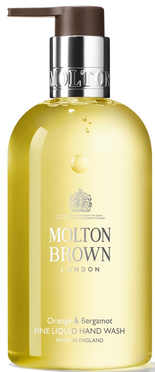En gul handtvättflaska med brunt pump och silverlock, märkt Molton Brown London, doft av apelsin och bergamot.