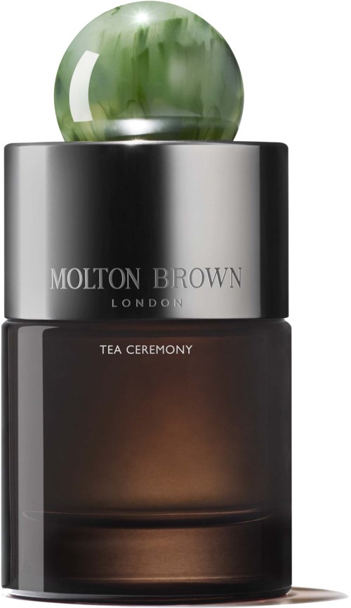 Ein Molton Brown London Duftflasche mit grünem kugelförmigem Deckel und dunklem Körper.