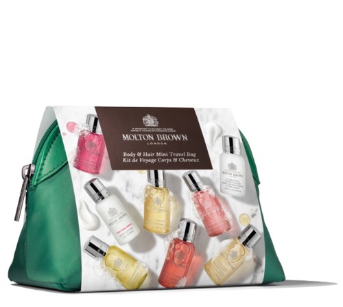 Een groene tas met Molton Brown toilettartikelen, waaronder verschillende gekleurde flesjes en een brochure, voor reizen.