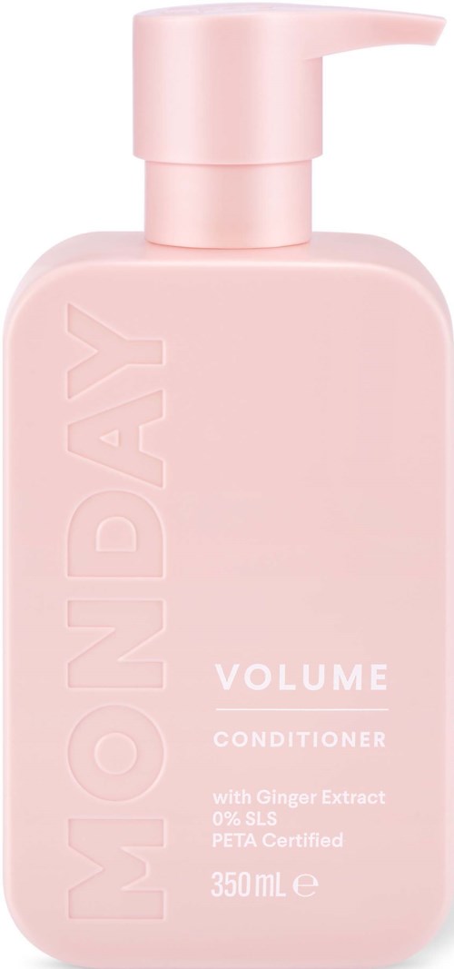 A pink bottle of volumizing conditioner with a pump. It has text mentioning ginger extract and natural ingredients.