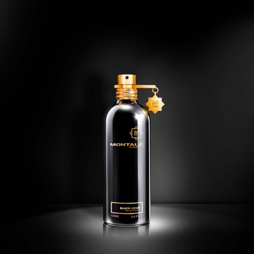 Een slanke zwarte fles met gouden accenten, een sprayneus en een gouden kaartje dat hangt. Het ziet er luxe en stijlvol uit.