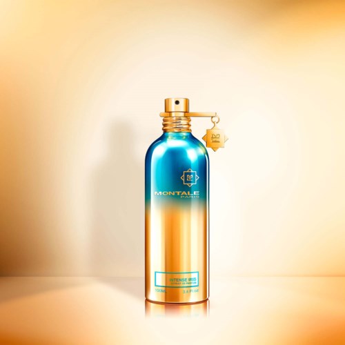 Een blauwe en gouden sprayfles met gouden dop, label en logo, staand tegen een lichte achtergrond.