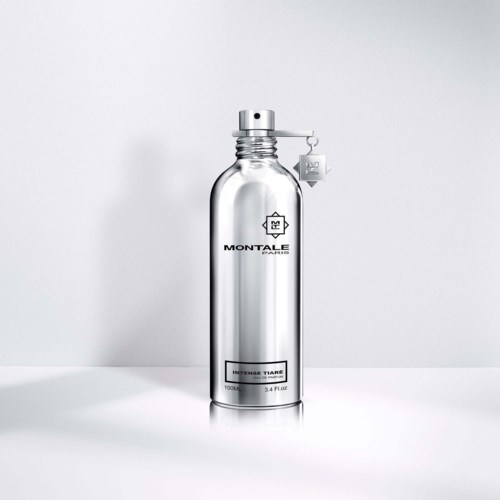 Een glanzende zilveren fles met een label, gemarkeerd 'Montale Paris' en 'Intense Tiare,' staat op een witte ondergrond.