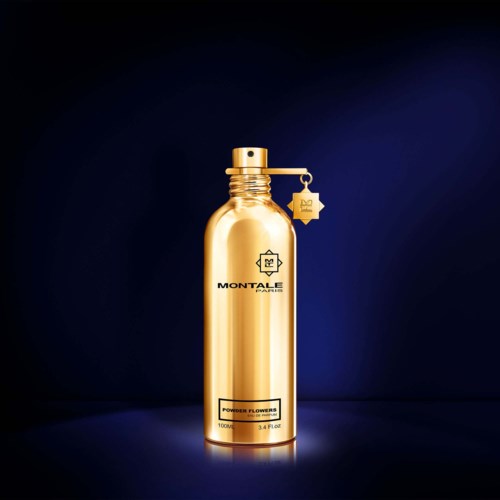 Een glanzende gouden sprayfles met tekst 'Montale Paris' en 'Powder Flowers' tegen een donkere achtergrond.