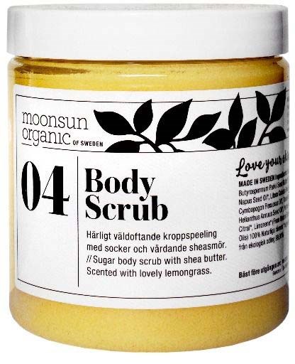 Gele pot met label 'Body Scrub' en zwart bladontwerp, bevat suikerscrub met shea boter en citroengeur.