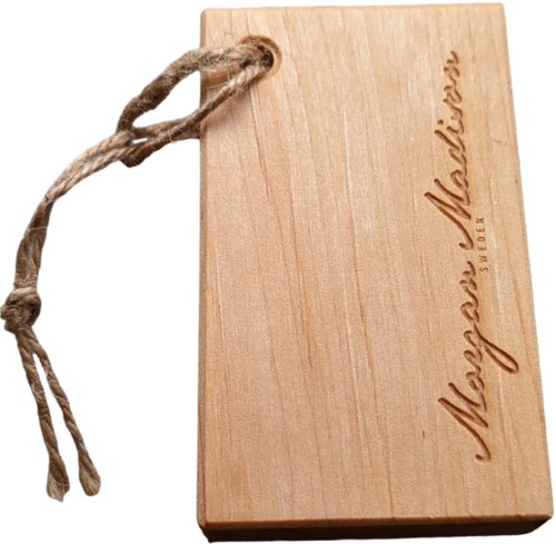 A wooden board with a string attached, engraved with the word "Mayshw" and some other text.