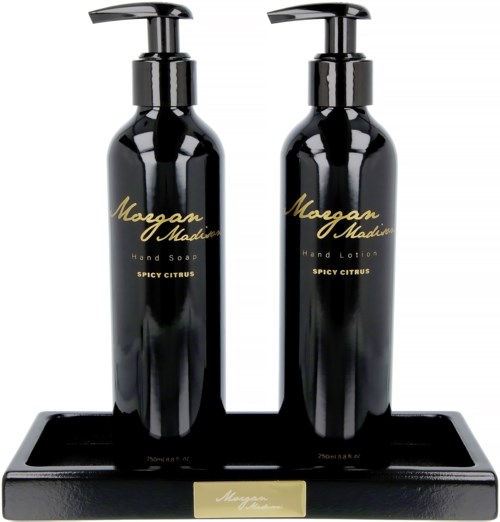 Two black bottles with gold writing and pumps sit on a black tray. Label says 'Moogan Madina, Spicy Citrus'.