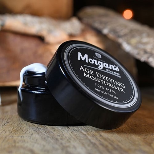 A black jar of Morgan's Age Defying Moisturiser for men on a wooden surface.