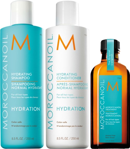 Three bottles of Moroccanoil hair care products: shampoo, conditioner, and treatment, all with orange and turquoise labels.