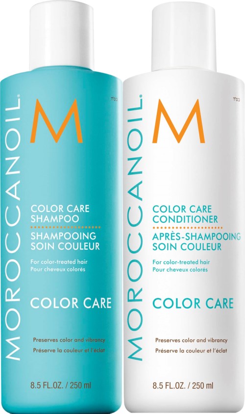 Two bottles of hair care products, one blue shampoo and one white conditioner, for color-treated hair.