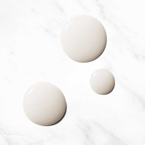 Three white spheres are placed on a marble surface, with two large and one small. They are shiny and smooth.