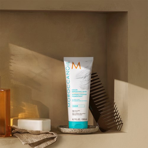 Moroccanoil väriä varten maski putkilo lautasella, lähistöllä harja ja saippua.