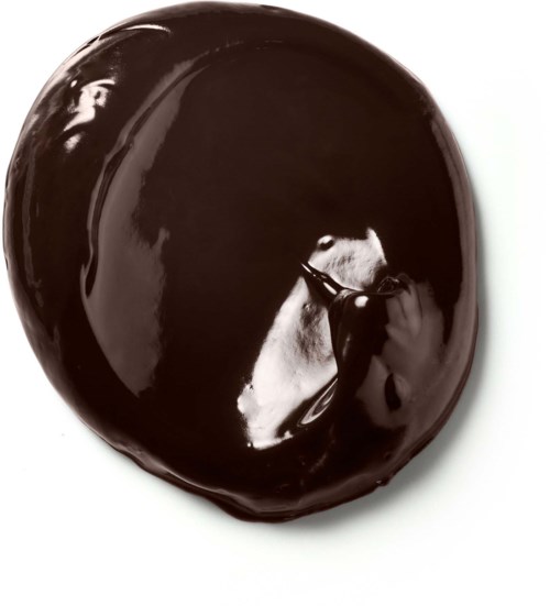 A shiny, dark, round object with a smooth surface reflecting a person taking a photo.