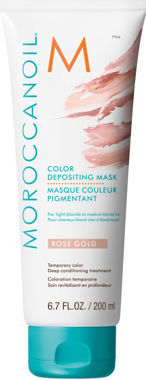 Valkoinen tubi Moroccanoil väriä jättävästä maskista, joissa on oransseja, sinisiä ja pinkkejä merkkejä. Mainitsee ruusukullan värin.