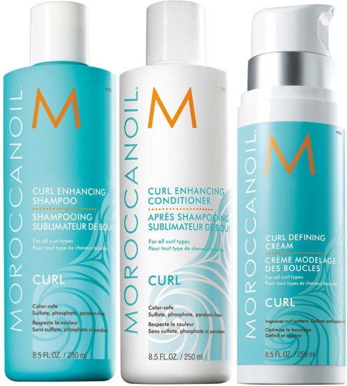 Three hair care products: shampoo, conditioner, and curling cream, all designed for curly hair, in blue and white bottles.