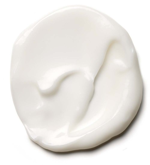 A dollop of white cream or yogurt on a plain white background.