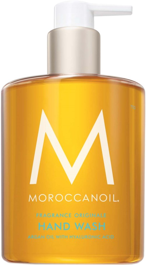 Oranssi pullo valkoisella pumpulla, merkki Morocco Oil Hand Wash, suuri valkoinen 'M'-logo.